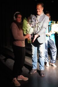 Man presents young woman with flowers.